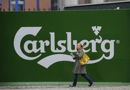 © Reuters/Nigel Roddis. Carlsberg announced job cuts in bid to curb expenses. Pictured: A woman walks past the Tetley's brewery in Leeds, northern England November 5, 2008.