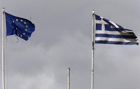 © Reuters/Yannis Behrakis. Frayed EU and Greek flags flutter atop the Greek Ministry of Finance in central Athens February 24, 2015.