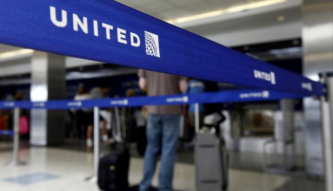 © Bloomberg. Travelers check in for a flight at a United Continental Holdings Inc. ticket counter at Los Angeles International Airport (LAX) in Los Angeles. Photographer: Patrick T. Fallon/Bloomberg