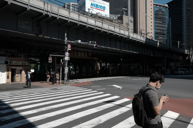 © Bloomberg. People wait to cross an intersection in the Shimbashi district in Tokyo, Japan, on Thursday, May 14, 2020. Japanese Prime Minister Shinzo Abe is looking to keep the state of emergency for Tokyo and Osaka even as he plans to lift it for 39 of the country’s 47 prefectures earlier than scheduled. Photographer: Soichiro Koriyama/Bloomberg