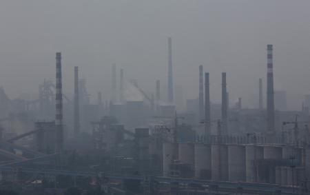 © Reuters. A steel factory is seen in smog during a hazy day in Anshan, Liaoning province on June 29, 2014.