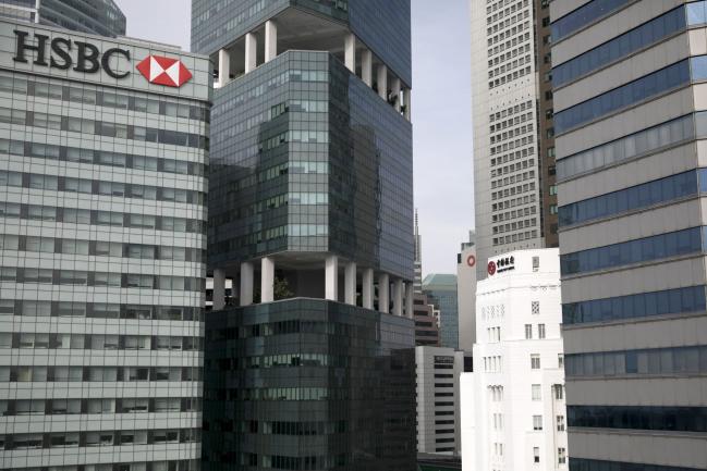 © Bloomberg. The HSBC Building, left, stands next to commercial buildings in Singapore, on Monday, June 11, 2018. President Donald Trump is about to see whether his bet on North Korea will pay off: that Kim Jong Un’s desire to end his country’s economic strangulation and pariah status will prevail over the dictator’s fear of relinquishing his nuclear threat. Photographer: Brent Lewin/Bloomberg
