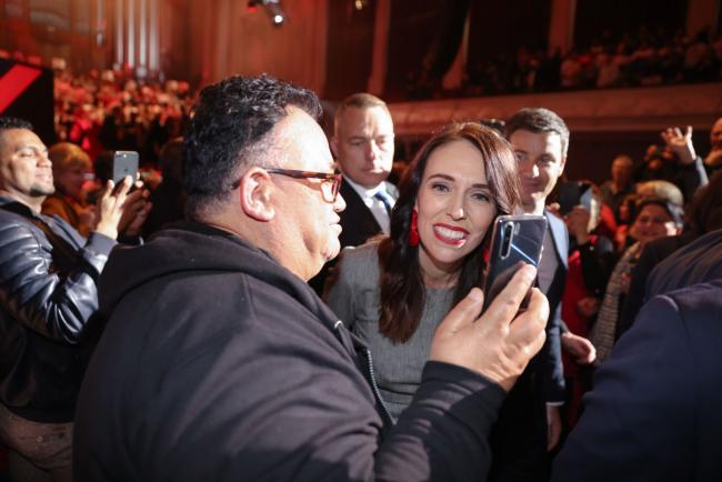 © Bloomberg. Jacinda Adern poses for a photograph with atendees during the Labour Party election campaign launch in Auckland, Aug. 8.