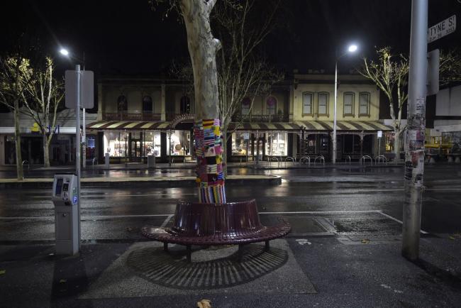 © Bloomberg. Lygon Street, the main shopping and dining street, stands deserted during curfew in the Carlton suburb of Melbourne on Aug 3.