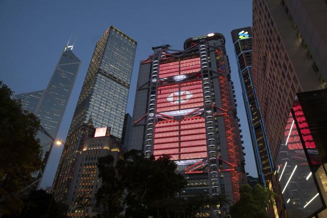 © Bloomberg. The HSBC Holdings Plc headquarters building, center, stands illuminated at dusk in Hong Kong, China, on Monday, April 27, 2020. HSBC is scheduled to release first-quarter earnings results on April 28.