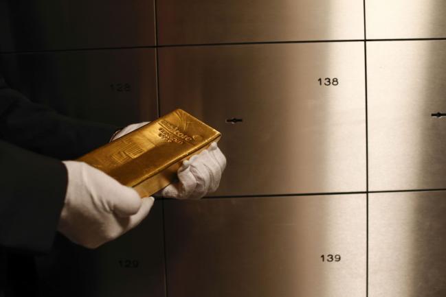 © Bloomberg. An employee holds a gold bar weighing 12.5 kilograms in the precious metals vault at Pro Aurum KG in Munich, Germany, on Wednesday, July 10, 2019. Gold rose for a third day after the Federal Reserve indicated that it’s preparing to cut interest rates for the first time in a decade as the global economy slows. Photographer: Michaela Handrek-Rehle/Bloomberg