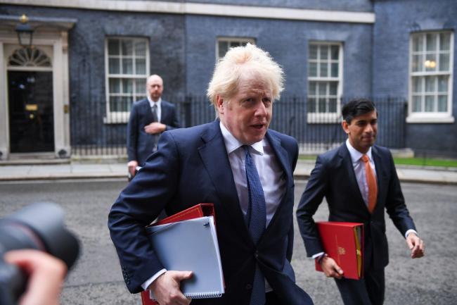 © Bloomberg. Boris Johnson, U.K. prime minister, center, and Rishi Sunak, U.K. chancellor of the exchequer, right, arrive for a weekly meeting of cabinet ministers in London, U.K., on Tuesday, Oct. 13, 2020. U.K. Prime Minister Boris Johnson announced bars and pubs will be closed in the worst-hit parts of England from Wednesday to control a surge in coronavirus, but his top health adviser said it won’t be enough.