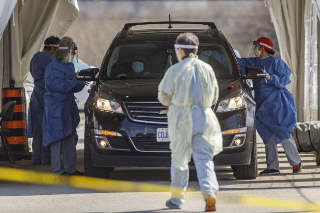 © Bloomberg. Healthcare workers administers Covid-19 tests at a drive through testing facility in Toronto, Ontario, Canada, on Wednesday, April 22, 2020. Ontario's premiere said that the economy won't re-open until the curve heads south.