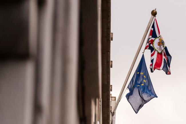 © Bloomberg. A British Union flag, also known as a Union Jack, with a Royal Coat of Arms flies from a flagpole with a European Union (EU) flag outside the offices of the U.K. Permanent Representation to the EU in Brussels, Belgium, on Tuesday, Jan. 28, 2020. It took 32 months, two prime ministers, and nearly 30 votes in Parliament to extricate Britain from the European Unionand the hardest part of the negotiations hasnt even started. Photographer: Geert Vanden Wijngaert/Bloomberg