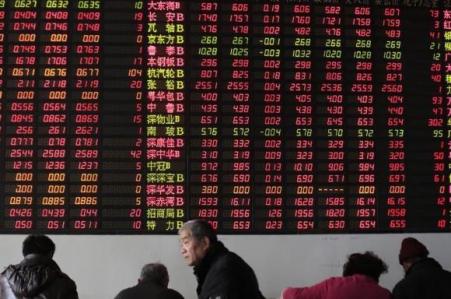 © Reuters/Aly Song. Investors look at computer screens in front of an electronic board showing stock information at a brokerage house in Shanghai on Dec. 31, 2014.