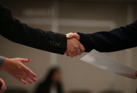 © Getty Images/Justin Sullivan. A job seeker shakes hands with a recruiter during a HireLive career fair on June 4, 2015 in San Francisco, California.