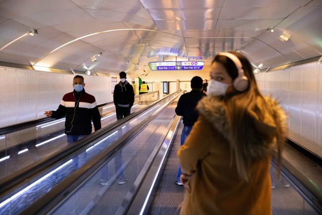 © Bloomberg. Travellers wearing protective face masks use moving walkways at Chatelet-Les-Halles metro station station in Paris on May 12. Photographer: Christophe Morin/Bloomberg