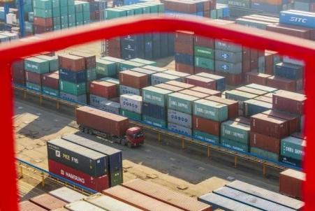 © Reuters. A truck drives past shipping containers at a port in Lianyungang, Jiangsu province on Jan. 23, 2015.