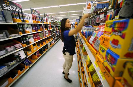 © Reuters Photographer. Calls for  an hour resonate with some Walmart workers. In this photo, department manager Karren Gomes stocks shelves for back-to-school shoppers at a San Diego Walmart, Aug. 6, 2015.