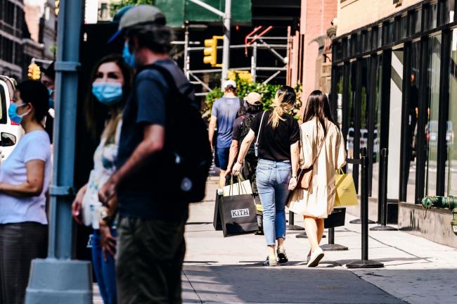 © Bloomberg. A pedestrian carries shopping bags while walking along a street in New York, U.S., on Thursday, Aug. 6, 2020. The Bloomberg Consumer Comfort index rose last week to 44.9 from 44.3 a week earlier. Photographer: Nina Westervelt/Bloomberg