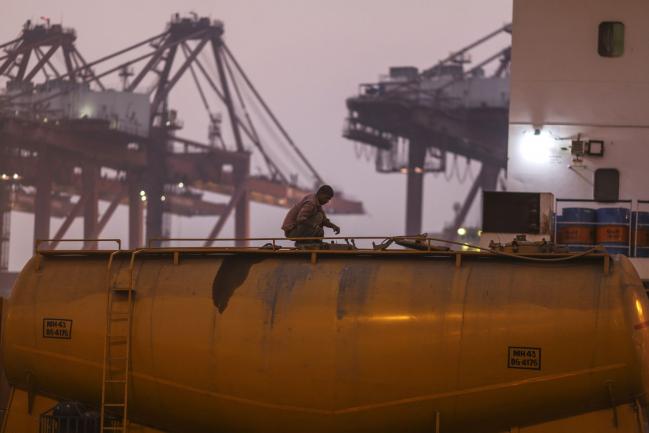 © Bloomberg. A driver checks a cement tanker truck at the Jawaharlal Nehru Port, operated by Jawaharlal Nehru Port Trust (JNPT), in Navi Mumbai, Maharashtra, India, on Saturday, Dec. 16, 2017. Many of the cargo containers passing through India's busiest port in Mumbai have a small piece of Japan Inc. attached: Devices from NEC Corp. that can be tracked as the containers rumble through the interior of Asia's third-largest economy. Photographer: Dhiraj Singh/Bloomberg