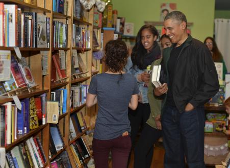 © Reuters/Mike Theiler. U.S. President Barack Obama and his daughters Malia (center) and Sasha (partly hidden) interact with Upshur Street Books manager Anna Thorn as they buy books from the store in Washington D.C., Nov. 28, 2015.