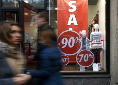 © Reuters. People walk past a shop with a sale advertisement in St. Petersburg November 7, 2014. Russia's central bank plans further steps to prop up the declining ruble, according to central bank first deputy chairman Sergei Shvetsov.