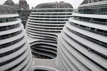 © Reuters/Kim Kyung-Hoon. A worker cleans an exterior of a newly built urban complex building accommodating offices and retail shops in Beijing on Oct. 14, 2013.