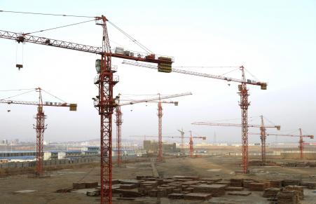 © Reuters. Cranes are seen above a residential construction site in Dalian, Liaoning province in this March 18, 2014 file photo.