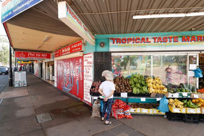 © Bloomberg. A person stands outside a grocery store during a partial lockdown imposed due to the coronavirus in Rooty Hill suburb of Sydney, Australia, on Saturday, April 4, 2020. Australia’s central bank this week warned of rising job losses and a likely “very material” contraction in economic activity, in minutes of an emergency meeting two weeks ago when it reduced the cash rate to the lower bound and unveiled unconventional policy measures. Photographer: Brendon Thorne/Bloomberg