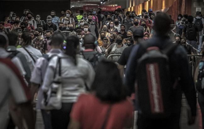 © Bloomberg. Commuters wear protective masks inside the Luz train station in Sao Paulo, Brazil, on Thursday, Oct. 8, 2020. Brazil reported 31,553 new cases Wednesday, pushing the total to 5,000,694, as mishmash quarantine measures continue to fade. Photographer: Jonne Roriz/Bloomberg