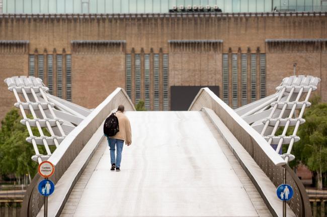 © Bloomberg. A pedestrian walks over the Millennium Bridge in London on May 11. Photographer: Jason Alden/Bloomberg