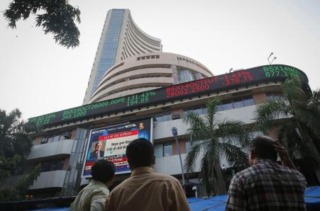 © Reuters. People watch a large screen displaying India's benchmark share index on the facade of the Bombay Stock Exchange