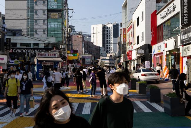 © Bloomberg. People wearing protective masks walk through the Hongdae shopping district in Seoul, South Korea, on Saturday, May 22, 2021. South Korea is scheduled to release consumer confidence figures on May 25.