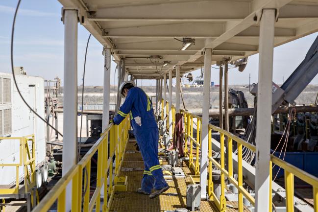 © Bloomberg. A roughneck walks on a Nabors Industries Ltd. drill rig as it is used to drill an oil well for Chevron Corp. in the Permian Basin near Midland, Texas, U.S., on Thursday, March 1, 2018. Chevron, the world's third-largest publicly traded oil producer, is spending $3.3 billion this year in the Permian and an additional $1 billion in other shale basins. Its expansion will further bolster U.S. oil output, which already exceeds 10 million barrels a day, surpassing the record set in 1970. Photographer: Daniel Acker/Bloomberg