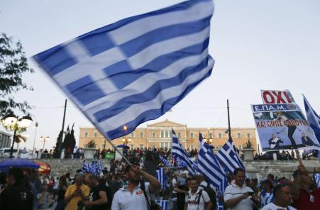 © Reuters/Yannis Behrakis. Anti-austerity 'No' voters celebrate the results of the first exit polls in front of the Greek parliament in Syntagma Square in Athens, Greece July 5, 2015. Greeks voted overwhelmingly 'No' on Sunday in a historic bailout referendum, partial results showed, defying warnings from across Europe that rejecting new austerity terms for fresh financial aid would set their country on a path out of the euro.