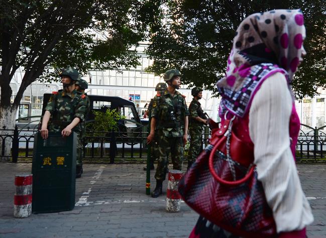 © Bloomberg. Chinese paramilitary police stand guard in the Muslim Uighur minority area of Urumqi, Xinjiang Province on June 30, 2013.