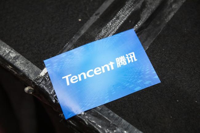 © Bloomberg. A sticker featuring the logo of Tencent Holdings Ltd. is seen during a news conference in Hong Kong, China, on Thursday, March 21, 2019. Tencent posted a quarterly profit that missed analysts’ estimates after it spent heavily on cloud and mobile payments businesses to offset a gaming slowdown. Photographer: Justin Chin/Bloomberg