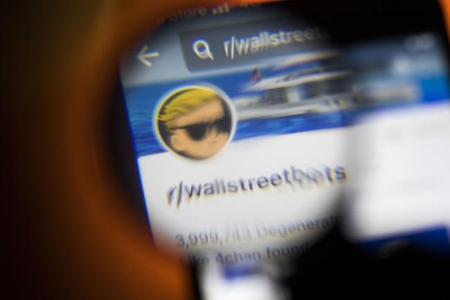 © Bloomberg. The Reddit forum WallStreetBets on a smartphone seen through a magnifying glass arranged in Sydney, Australia, on Thursday, Jan. 28, 2021. WallStreetBets, the internet forum fueling a frenzy of retail trading, briefly turned itself off to new users Wednesday after a deluge of new participants raised concerns about its ability to police content, a notice on the website said. Photographer: Brent Lewin/Bloomberg