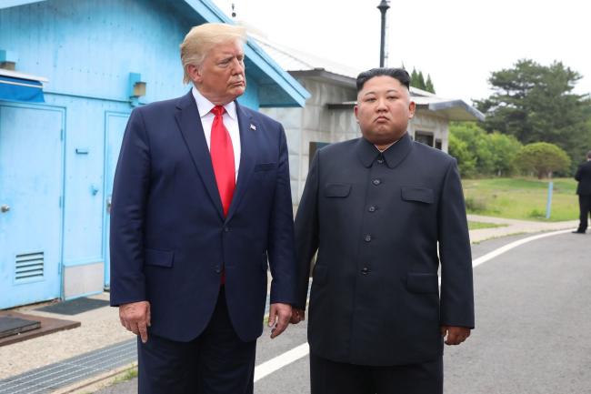 © Bloomberg. Kim Jong Un and Donald Trump inside the demilitarized zone in June 2019.