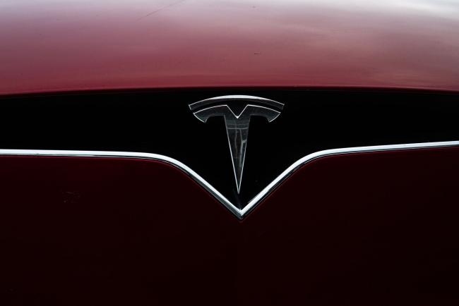 © Bloomberg. A logo is displayed on a Tesla Inc. electric vehicle charging at the Tesla Supercharger station in Fremont, California, U.S., on Monday, July 20, 2020. Tesla Inc. is scheduled to release earnings figures on July 22. Photographer: Nina Riggio/Bloomberg