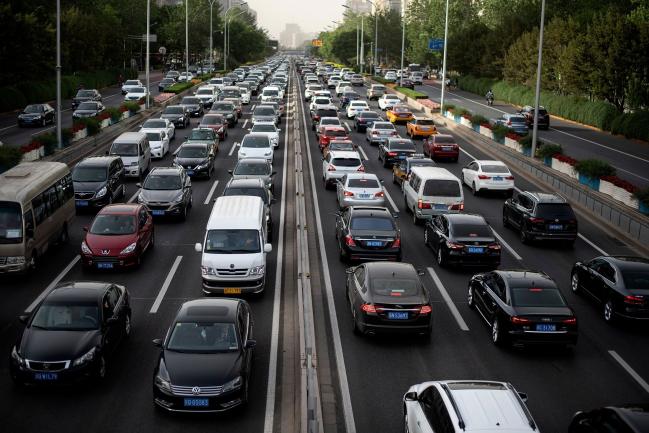 © Bloomberg. TOPSHOT - Commuters make their way along a busy road in Beijing on May 12, 2020.  Photographer: Noel Celis/AFP via Getty Images