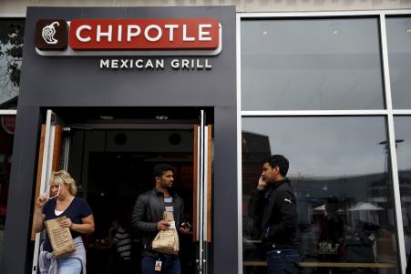 © Reuters/Robert Galbraith. Fifty-two people nationwide have fallen ill from an E.coli infection linked to Chipotle restaurants. In this photo, people carry bags as they leave a Chipotle Mexican Grill restaurant in San Francisco, July 21, 2015.