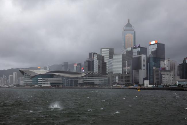 © Bloomberg. Clouds gather over the Hong Kong Convention and Exhibition Centre, left, and other buildings during a No. 8 Storm Signal raised for tropical storm Wipha in Hong Kong, China, on Wednesday, July 31, 2019. A tropical storm shut Hong Kong’s financial markets for the first time in almost two years, adding extra drama to a city that’s been wracked by protests for weeks. Photographer: Kyle Lam/Bloomberg