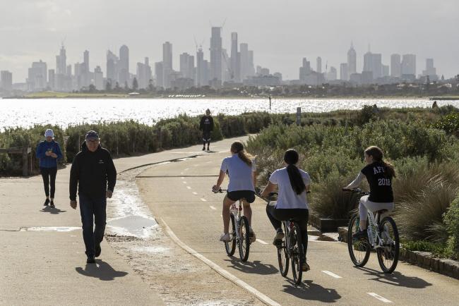 © Bloomberg. MELBOURNE, AUSTRALIA - MAY 13: People walk and ride along the beach at Brighton on May 13, 2020 in Melbourne, Australia. COVID-19 restrictions have eased slightly for Victorians in response to Australia's declining coronavirus (COVID-19) infection rate. From today, people in Victoria will be allowed to visit friends and family. A maximum gathering of up to ten outdoors is allowed, or up to five visitors inside a home. Golfing, hiking and fishing is also now permitted. (Photo by Daniel Pockett/Getty Images)