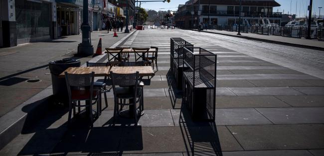 © Bloomberg. Empty tables and chairs stand outside a restaurant on Jefferson Street at Fisherman's Wharf in San Francisco, California, U.S., on Wednesday, July 8, 2020.