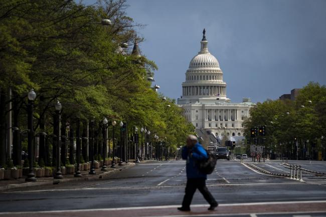© Bloomberg. A pedestrian crosses a street past the U.S. Capitol in Washington, D.C. on April 13. Photographer: Al Drago/Bloomberg