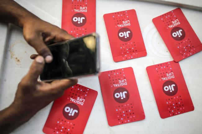 © Bloomberg. Sim card packets for Reliance Jio, the mobile network of Reliance Industries Ltd., are arranged for a photograph at a store in Mumbai, India, on Sunday, Jan. 19, 2020. Reliance Industries, India's biggest company by market value, posted a 13.5% jump in quarterly net income as growth in telecom and retail business helped outweigh a slump in petrochemical operations. Photographer: Dhiraj Singh/Bloomberg