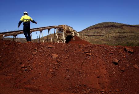 © REUTERS/David Gray. Fortescue Chief Executive Officer (CEO) Nev Power climbs a pile of iron ore at the Fortescue Solomon iron ore mine located in the Valley of the Kings, around 248 miles south of Port Hedland in the Pilbara region of Western Australia. Mining production fell by three percent this quarter in Australia.