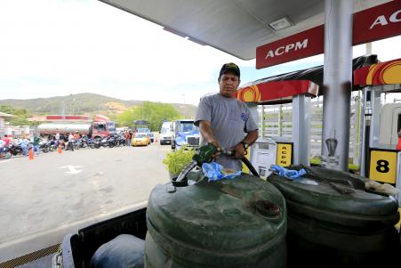© REUTERS/Jose Miguel Gomez. A man fills tanks with gas in Cucuta, Colombia, Aug. 26, 2015. Oil fell below  a barrel on Monday.