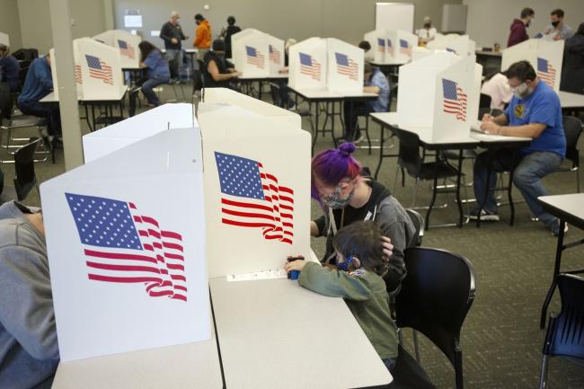 © Bloomberg. Voters wearing protective masks cast ballots at a polling location for the 2020 Presidential election in Des Moines, Iowa, U.S., on Tuesday, Nov. 3, 2020. American voters, at least those who've not yet cast ballots, go to the polls Tuesday to choose between President Donald Trump and Democratic nominee Joe Biden and cast votes in U.S. House and Senate races and state and local elections. Photographer: Rachel Mummey/Bloomberg