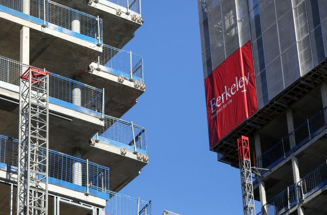 © Bloomberg. The Berkeley Group Holdings Plc company logo is displayed on the side of a block of residential apartments under construction at the company's Woodberry Down development in London, U.K., on Friday, Jan. 20, 2017. Berkeley rose the most in almost three months after London's biggest homebuilder reported a 34 percent increase in pretax profit and set new five-year earnings targets. Photographer: Chris Ratcliffe/Bloomberg