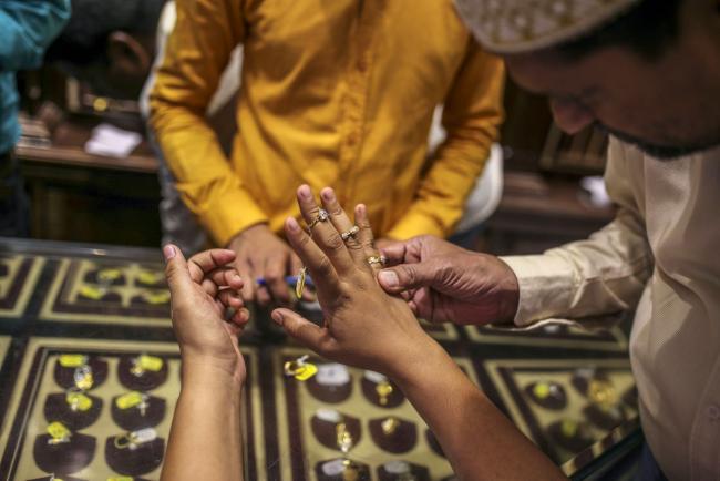 © Bloomberg. A customer tries on rings inside a Titan Co. Tanishq jewelry store during the festival of Dhanteras in Mumbai, India, on Friday, Oct. 25, 2019. Gold sales on the most auspicious day in India to buy the metal tumbled this year as high prices and concerns about an economic slowdown saw customers limit purchases. Photographer: Dhiraj Singh/Bloomberg