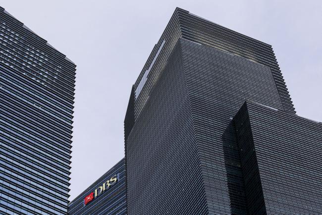 © Bloomberg. The DBS Group Holdings Ltd. logo is displayed atop Tower 3 of the Marina Bay Financial Centre in Singapore, on Wednesday, Feb. 12, 2020. The coronavirus outbreak rocked Singapore's financial district after an infection at the country’s biggest bank prompted it to evacuate 300 workers.