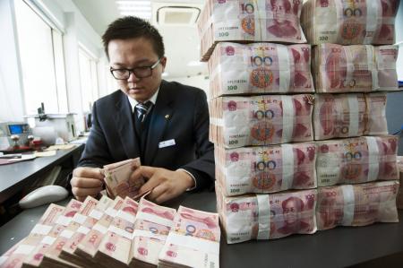 © Reuters/China Daily. A clerk counts Chinese 100 yuan banknotes at a branch of China Construction Bank in Nantong, Jiangsu province on Dec. 2, 2014.